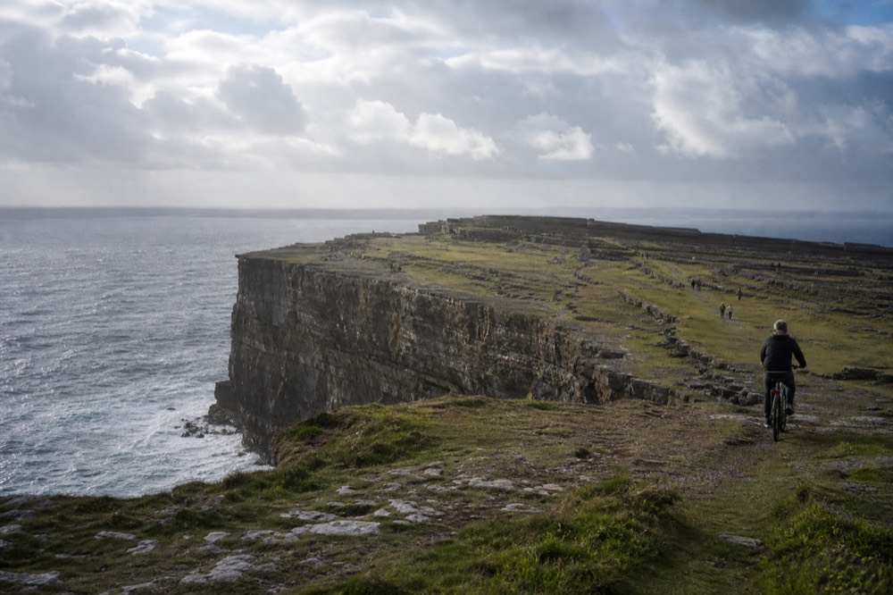 The stone fort of Dún Aonghasa on the cliff edge of Inis Mór, bikes and walkers on the green island paths, the Atlantic wrapping the coast far below.
